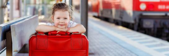 Kindje met koffer in een treinstation